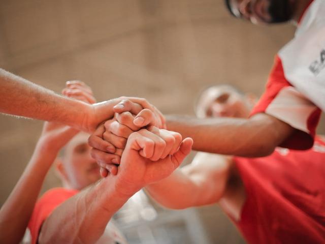 Photo équipe de sport empilant les mains