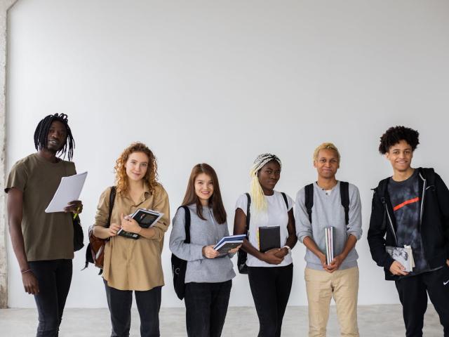 Photo de jeunes portant des livres et des cahiers