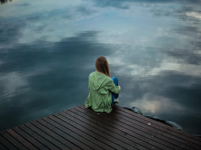 Femme de dos devant un lac