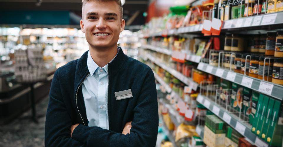 Jeune vendeur devant un rayon