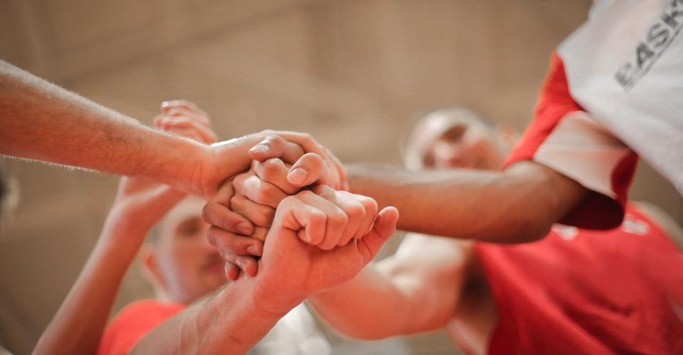 Photo équipe de sport empilant les mains