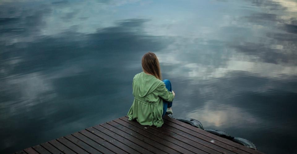 Femme de dos devant un lac